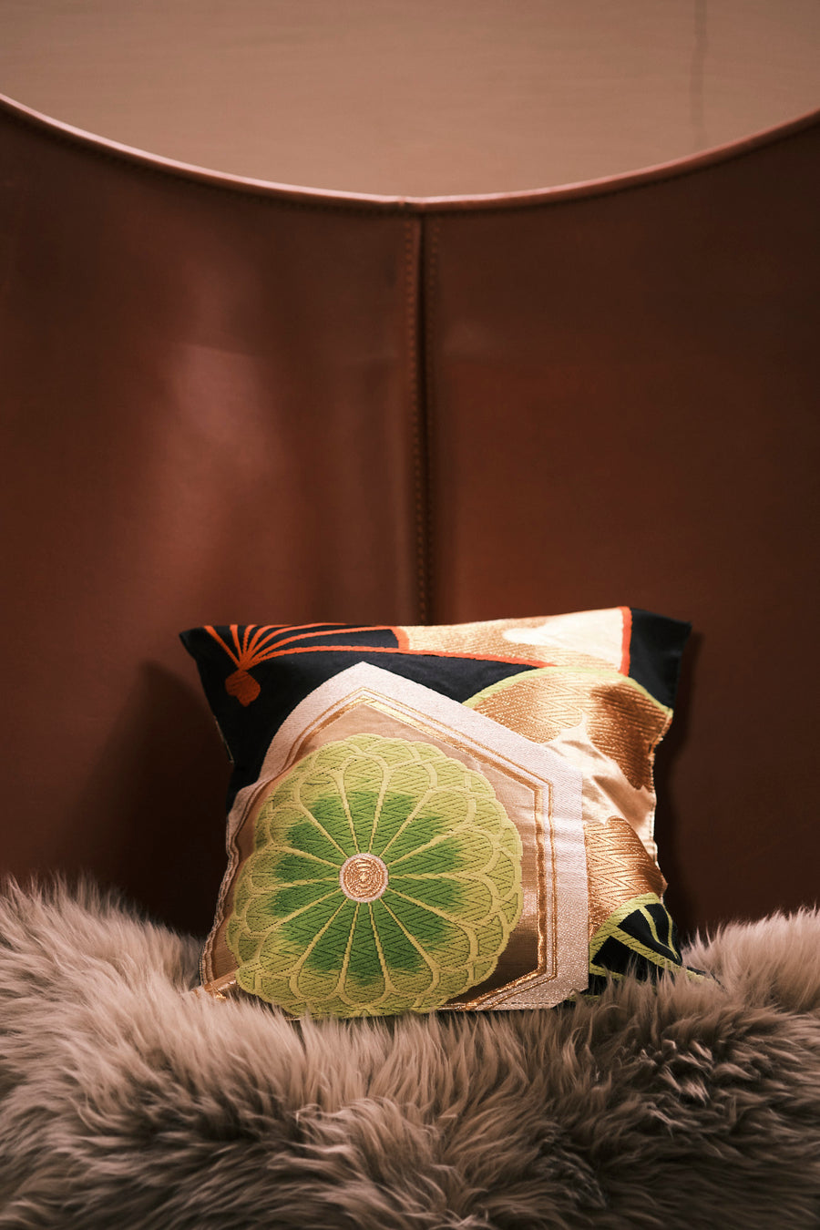 An obi cushion — kimono silk given a second life — resting on a sheepskin